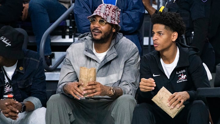 Carmelo Anthony and his son, Kiyan, watch the Don Bosco Prep Ironmen compete against the McEachern Indians