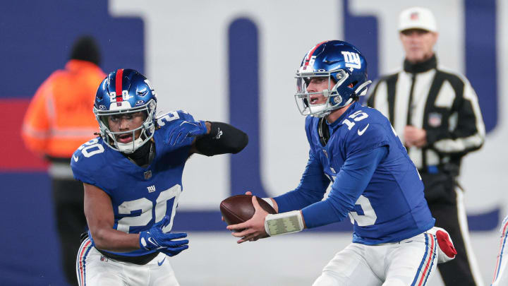 New York Giants quarterback Tommy DeVito (15) fakes a handoff to running back Eric Gray (20). 