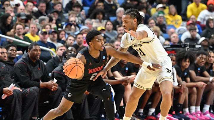 Mar 19, 2026; Buffalo, NY, USA; Howard Bison guard Cam Gillus (2) passes the ball against Michigan Wolverines forward Morez Johnson Jr. (21) during the second half of a first round game of the men's 2026 NCAA Tournament at Keybank Center. Mandatory Credit: Mark Konezny-Imagn Images Mar 19, 2026; Buffalo, NY, USA; Howard Bison guard Cam Gillus (2) passes the ball against Michigan Wolverines forward Morez Johnson Jr. (21) during the second half of a first round game of the men's 2026 NCAA Tournament at Keybank Center. Mandatory Credit: Mark Konezny-Imagn Images