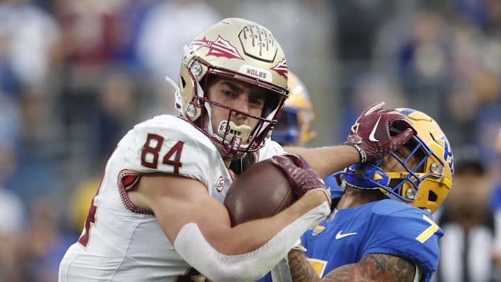 Nov 4, 2023; Pittsburgh, Pennsylvania, USA;  Florida State Seminoles tight end Kyle Morlock (84) stiff arms Pittsburgh Panthers defensive back Javon McIntyre (7) after a catch during the second quarter at Acrisure Stadium. Mandatory Credit: Charles LeClaire-Imagn Images