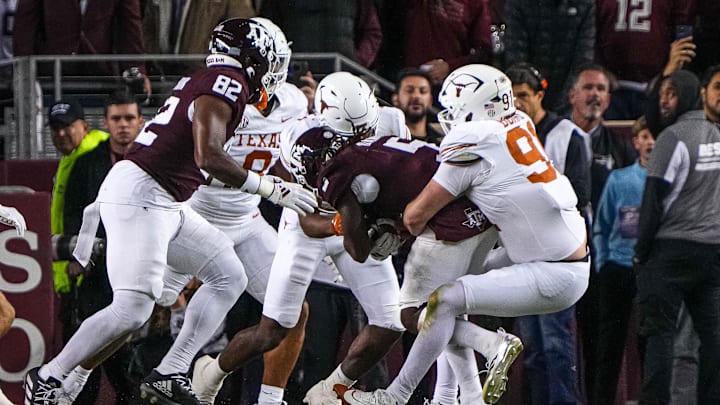 Nov 30, 2024; College Station, Texas, USA; Texas longhorns edge rusher Ethan Burke (91) stops Texas A&M running back Amari Daniels (5) on fourth and goal at the 1-yard line during the Lone Star Showdown at Kyle Field. Mandatory Credit: Sara Diggins/USA TODAY Network via Imagn Images Nov 30, 2024; College Station, Texas, USA; Texas longhorns edge rusher Ethan Burke (91) stops Texas A&M running back Amari Daniels (5) on fourth and goal at the 1-yard line during the Lone Star Showdown at Kyle Field. Mandatory Credit: Sara Diggins/USA TODAY Network via Imagn Images