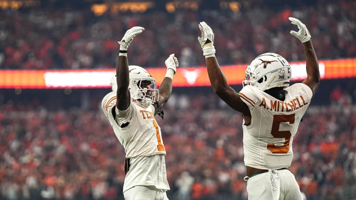 Texas Longhorns wide receivers Adonai Mitchell (5) and Xavier Worthy (1) celebrate a touchdown by Mitchell during the Big 12 Championship game against the Oklahoma State Cowboys at AT&T stadium on Saturday, Dec. 2, 2023 in Arlington.