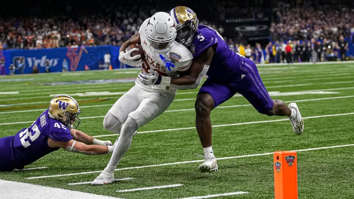 Texas Longhorns running back Jaydon Blue (23) is pushed tackled near the endzone by Washington linebacker Edefuan Ulofoshio (5) during the Sugar Bowl College Football Playoff semifinals game at the Caesars Superdome on Monday, Jan. 1, 2024 in New Orleans, Louisiana. Texas Longhorns running back Jaydon Blue (23) is pushed tackled near the endzone by Washington linebacker Edefuan Ulofoshio (5) during the Sugar Bowl College Football Playoff semifinals game at the Caesars Superdome on Monday, Jan. 1, 2024 in New Orleans, Louisiana.