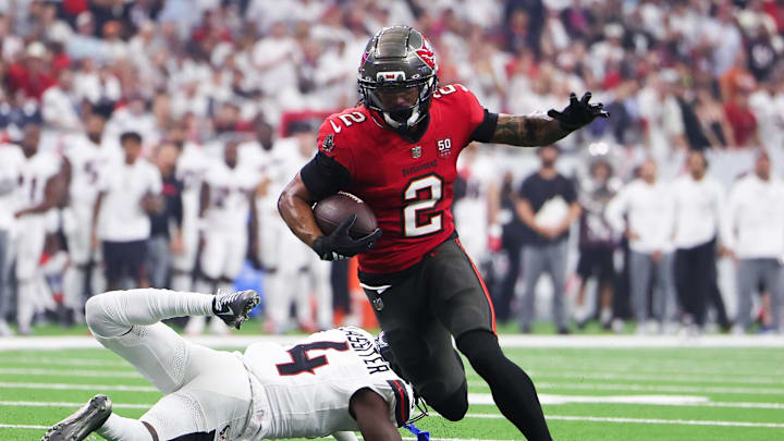 Sep 15, 2025; Houston, Texas, USA; Tampa Bay Buccaneers wide receiver Emeka Egbuka (2) runs for a touchdown as Houston Texans cornerback Kamari Lassiter (4) defends during the second quarter at NRG Stadium. Mandatory Credit: Troy Taormina-Imagn Images