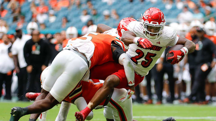 Nov 18, 2023; Miami Gardens, Florida, USA; Louisville Cardinals running back Jawhar Jordan (25) runs with the football but is tackled short of the end zone by Miami Hurricanes safety Kamren Kinchens (5) during the second quarter at Hard Rock Stadium. Nov 18, 2023; Miami Gardens, Florida, USA; Louisville Cardinals running back Jawhar Jordan (25) runs with the football but is tackled short of the end zone by Miami Hurricanes safety Kamren Kinchens (5) during the second quarter at Hard Rock Stadium.
