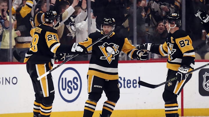 Feb 25, 2024; Pittsburgh, Pennsylvania, USA;  Pittsburgh Penguins defenseman Marcus Pettersson (28) and center Sidney Crosby (87) congratulate right wing Bryan Rust (17) after Rust scored a goal against the Philadelphia Flyers during the first period at PPG Paints Arena. Mandatory Credit: Charles LeClaire-Imagn Images