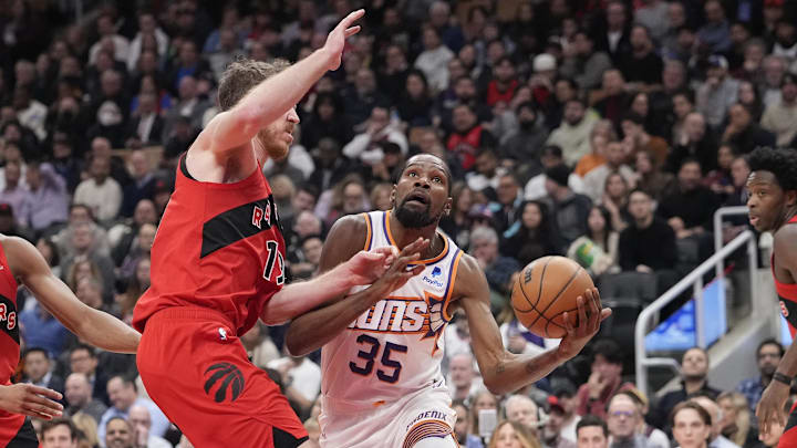 Nov 29, 2023; Toronto, Ontario, CAN; Phoenix Suns forward Kevin Durant (35) drives to the net against Toronto Raptors center Jakob Poeltl (19) during the first half at Scotiabank Arena. Mandatory Credit: John E. Sokolowski-Imagn Images