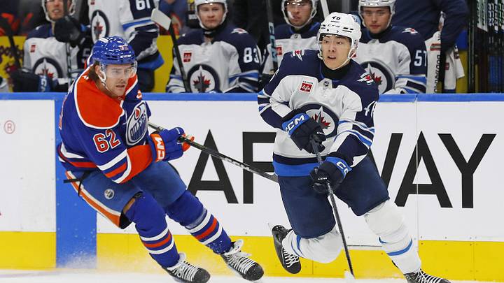 Sep 22, 2024; Edmonton, Alberta, CAN; Winnipeg Jets forward Kevin He (46) makes a pass in front of Edmonton Oilers forward Raphael Lavoie (62) during the first period at Rogers Place. Mandatory Credit: Perry Nelson-Imagn Images
