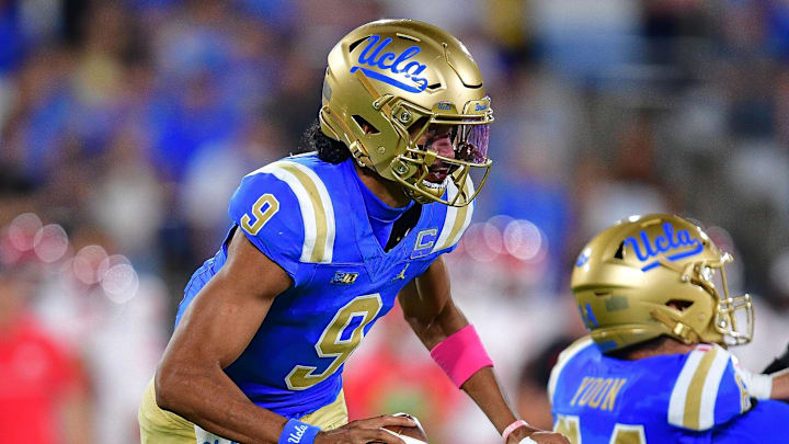 Aug 30, 2025; Pasadena, California, USA; UCLA Bruins quarterback Nico Iamaleava (9) runs the ball as offensive lineman Sam Yoon (64) provides coverage against Utah Utes linebacker Lander Barton (8) during the second half at Rose Bowl. Mandatory Credit: Gary A. Vasquez-Imagn Images