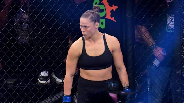 May 16, 2026; Los Angeles, California, USA;  Ronda Rousey (blue gloves) looks on before fighting Gina Carano (red gloves) in a women's featherweight bout at Intuit Dome. Mandatory Credit: Jayne Kamin-Oncea-Imagn Images