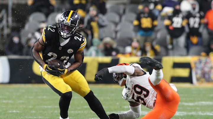 Jan 4, 2025; Pittsburgh, Pennsylvania, USA;  Pittsburgh Steelers running back Najee Harris (22) sheds a tackle attempt by Cincinnati Bengals linebacker Akeem Davis-Gaither (59) after catching a pass during the fourth quarter at Acrisure Stadium. Mandatory Credit: Charles LeClaire-Imagn Images