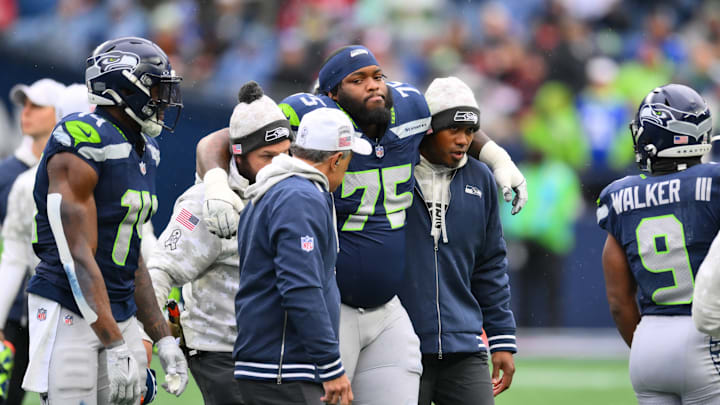 Nov 24, 2024; Seattle, Washington, USA; Seattle Seahawks guard Anthony Bradford (75) is helped off the field during the first half against the Arizona Cardinals at Lumen Field.