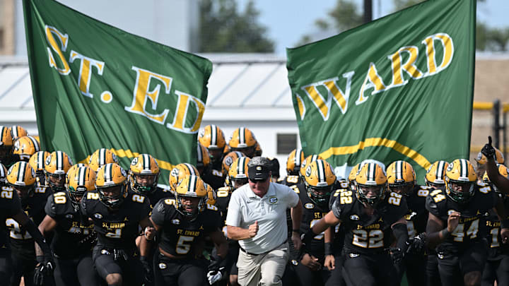 St. Edward football head coach Tom Lombardo leads the Eagles onto the field before a game against Elder on September 10, 2022. 
