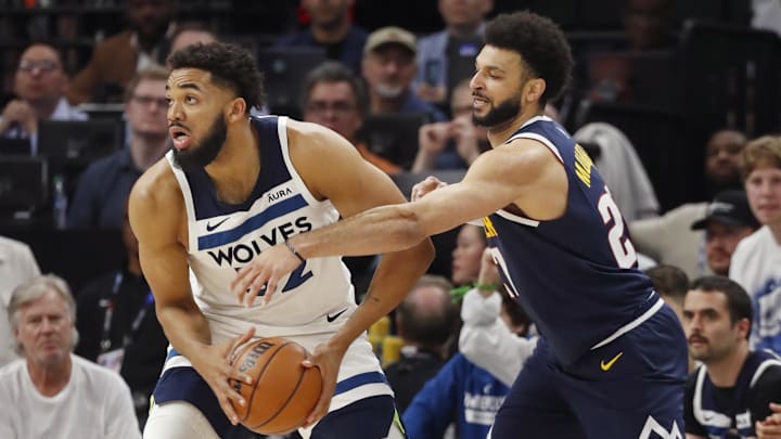May 12, 2024; Minneapolis, Minnesota, USA; Minnesota Timberwolves forward Karl-Anthony Towns (32) works to get the ball away from Denver Nuggets guard Jamal Murray (27) in the first quarter of game four of the second round for the 2024 NBA playoffs at Target Center. 