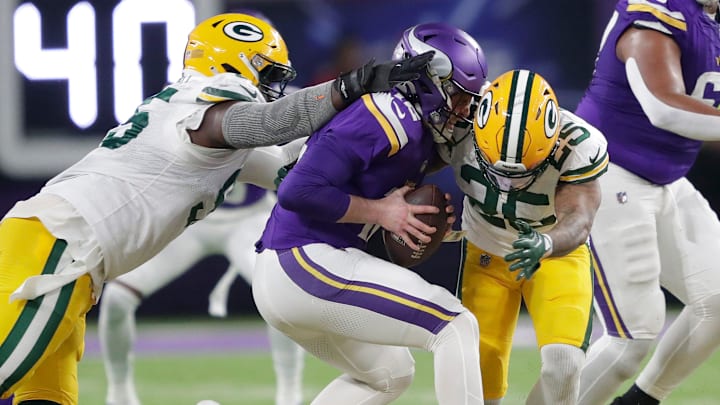 Green Bay Packers defensive tackle Devonte Wyatt (95) and cornerback Keisean Nixon (25) sack Jaren Hall last season.