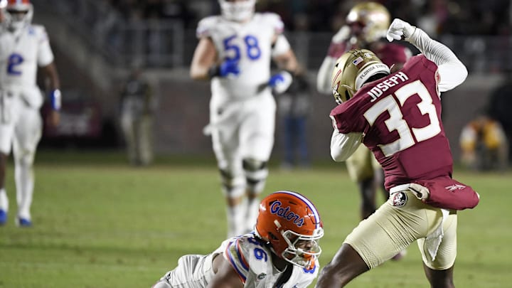 Nov 30, 2024; Tallahassee, Florida, USA; Florida State Seminoles defensive back Edwin Joseph (33) strips the ball from Florida Gators tight end Tony Livingston (86) during the first half at Doak S. Campbell Stadium. Mandatory Credit: Melina Myers-Imagn Images