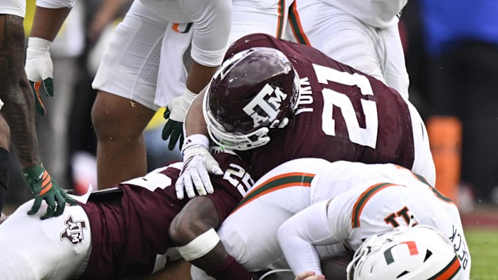 Texas A&M Aggies safety Dalton Brooks (25) and linebacker Taurean York (21) sack Miami Hurricanes quarterback Carson Beck (11) during first half of the first round game of the CFP National Playoff at Kyle Field. 