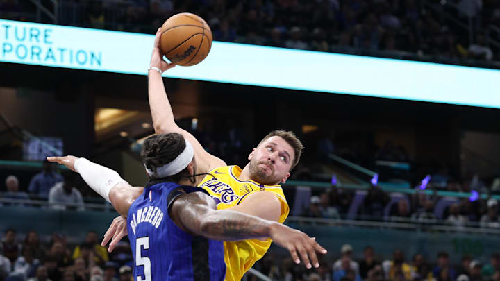 Mar 24, 2025; Orlando, Florida, USA; Los Angeles Lakers guard Luka Doncic (77) passes teh ball against the Orlando Magic in the second quarter at Kia Center. Mandatory Credit: Nathan Ray Seebeck-Imagn Images