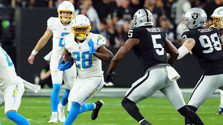 Dec 14, 2023; Paradise, Nevada, USA; Los Angeles Chargers running back Isaiah Spiller (28) runs against Las Vegas Raiders linebacker Divine Deablo (5) in the second quarter at Allegiant Stadium. Mandatory Credit: Stephen R. Sylvanie-USA TODAY Sports