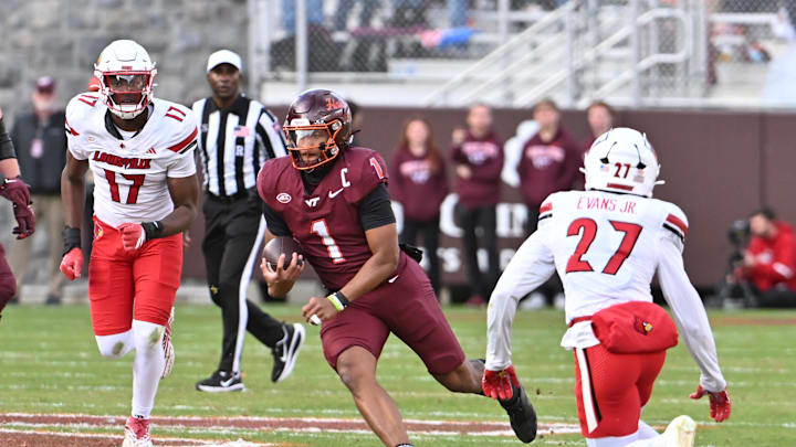 Nov 1, 2025; Blacksburg, Virginia, USA; Virginia Tech Hokies quarterback Kyron Drones (1) runs the ball as Louisville Cardinals defensive back Jojo Evans Jr. (27) defends during the second quarter at Lane Stadium. Mandatory Credit: Brian Bishop-Imagn Images Nov 1, 2025; Blacksburg, Virginia, USA; Virginia Tech Hokies quarterback Kyron Drones (1) runs the ball as Louisville Cardinals defensive back Jojo Evans Jr. (27) defends during the second quarter at Lane Stadium. Mandatory Credit: Brian Bishop-Imagn Images