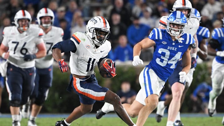 Nov 15, 2025; Durham, North Carolina, USA;  Virginia Cavaliers wide receiver Trell Harris (11) controls the ball around Duke Blue Devils linebacker Luke Mergott (34) during the third quarter at Wallace Wade Stadium. Mandatory Credit: Zachary Taft-Imagn Images