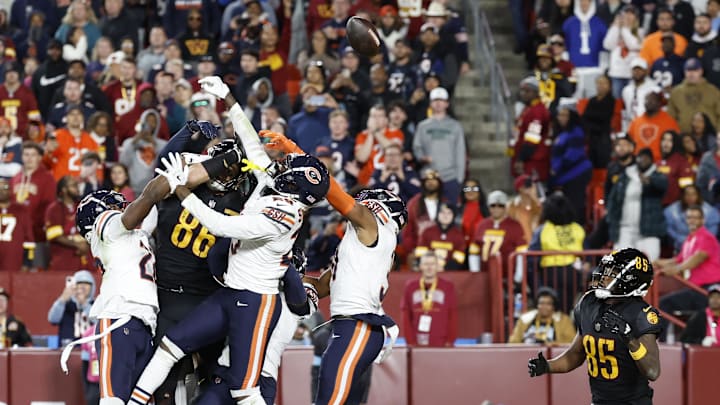 Bears and Commanders player jump up to grab a Hail Mary at the end of Sunday’s game.