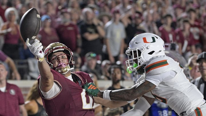 Oct 4, 2025; Tallahassee, Florida, USA; Florida State Seminoles wide receiver Duce Robinson reaches for a ball against Miami Hurricanes cornerback Xavier Lucas (6) during the first half at Doak S. Campbell Stadium. Mandatory Credit: Melina Myers-Imagn Images