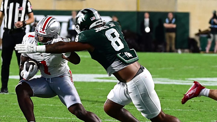 Sep 28, 2024; East Lansing, Michigan, USA;  Michigan State Spartans defensive lineman Anthony Jones (8) tackles Ohio State Buckeyes wide receiver Jeremiah Smith (4) in the first quarter at Spartan Stadium. Mandatory Credit: Dale Young-Imagn Images