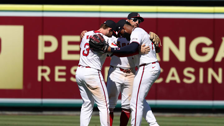 Jul 28, 2024; Anaheim, California, USA;  Los Angeles Angels left fielder Taylor Ward (3) and center fielder Kevin Pillar (12) and right fielder Jo Adell (7) celebrate a victory after defeating the Oakland Athletics 8-6 at Angel Stadium. Mandatory Credit: Kiyoshi Mio-Imagn Images