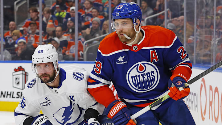 Dec 10, 2024; Edmonton, Alberta, CAN; Tampa Bay Lightning forward Nikita Kucherov (86) and Edmonton Oilers forward Leon Draisaitl (29) look for a loose puck during the second period at Rogers Place. Mandatory Credit: Perry Nelson-Imagn Images