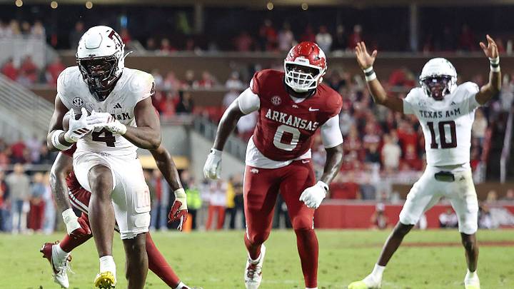 Texas A&M Aggies running back Rueben Owens II (4) rushes for a touchdown during the fourth quarter as quarterback Marcel Reed (10) and Arkansas Razorbacks defensive lineman Justus Boone (0) look on at Donald W. Reynolds Razorback Stadium.