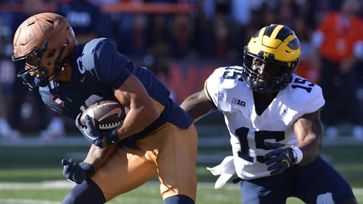Oct 19, 2024; Champaign, Illinois, USA;  Illinois Fighting Illini wide receiver Pat Bryant (13) makes a short catch and run against Michigan Wolverines linebacker Ernest Hausmann (15) during the first half at Memorial Stadium. Mandatory Credit: Ron Johnson-Imagn Images