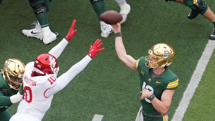 Nov 29, 2025; Waco, Texas, USA; Baylor Bears quarterback Sawyer Robertson (13) looks to pass as Houston Cougars defensive end Latreveon McCutchin (10) defends during the first half at McLane Stadium. Mandatory Credit: Chris Jones-Imagn Images