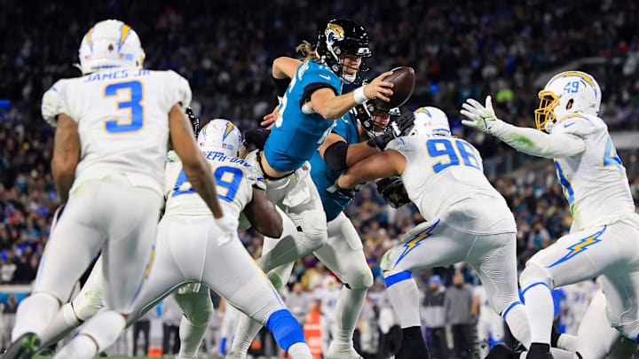 Jacksonville Jaguars quarterback Trevor Lawrence (16) scores a two point conversion between Los Angeles Chargers defensive tackle Sebastian Joseph-Day (69) and defensive tackle Breiden Fehoko (96) during the fourth quarter of an NFL first round playoff football matchup Saturday, Jan. 14, 2023 at TIAA Bank Field in Jacksonville, Fla. The Jacksonville Jaguars edged the Los Angeles Chargers on a field goal 31-30.