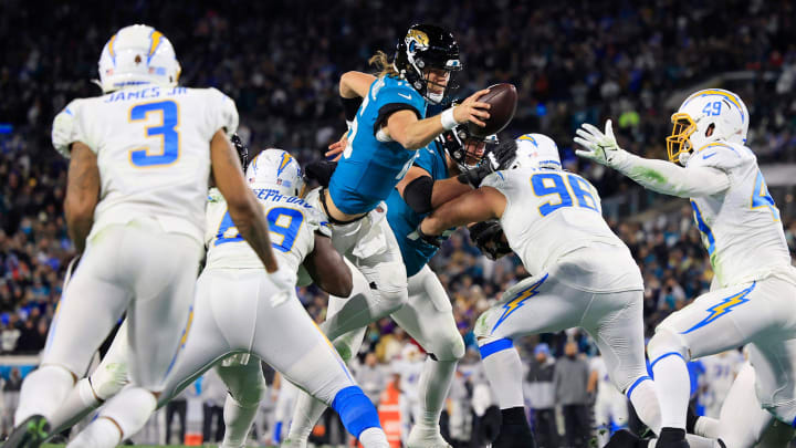 Jacksonville Jaguars quarterback Trevor Lawrence (16) scores a two point conversion between Los Angeles Chargers defensive tackle Sebastian Joseph-Day (69) and defensive tackle Breiden Fehoko (96) during the fourth quarter of an NFL first round playoff football matchup Saturday, Jan. 14, 2023 at TIAA Bank Field in Jacksonville, Fla. The Jacksonville Jaguars edged the Los Angeles Chargers on a field goal 31-30.