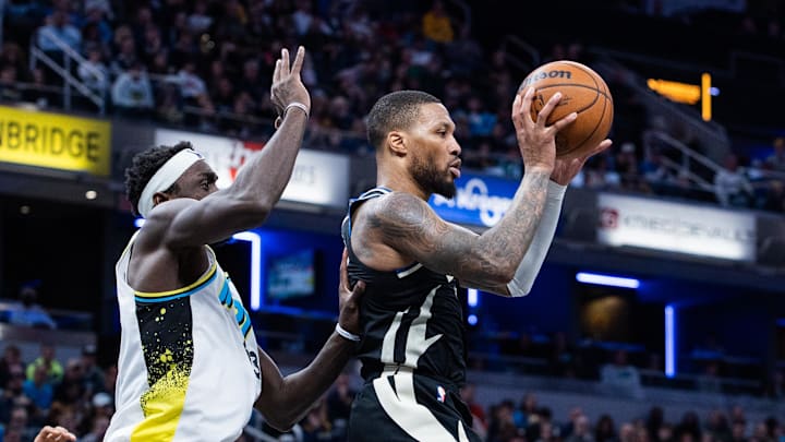 Dec 31, 2024; Indianapolis, Indiana, USA; Milwaukee Bucks guard Damian Lillard (0) passes the ball while Indiana Pacers forward Pascal Siakam (43) defends in the second half at Gainbridge Fieldhouse. Mandatory Credit: Trevor Ruszkowski-Imagn Images