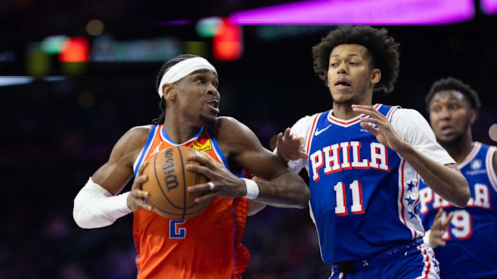 Jan 14, 2025; Philadelphia, Pennsylvania, USA; Oklahoma City Thunder guard Shai Gilgeous-Alexander (2) drives against Philadelphia 76ers guard Jeff Dowtin Jr. (11) during the third quarter at Wells Fargo Center. Mandatory Credit: Bill Streicher-Imagn Images Jan 14, 2025; Philadelphia, Pennsylvania, USA; Oklahoma City Thunder guard Shai Gilgeous-Alexander (2) drives against Philadelphia 76ers guard Jeff Dowtin Jr. (11) during the third quarter at Wells Fargo Center. Mandatory Credit: Bill Streicher-Imagn Images