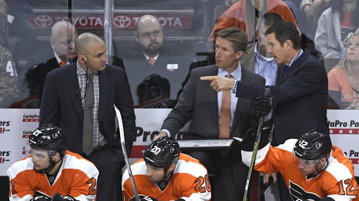 Oct 29, 2015; Philadelphia, PA, USA; Philadelphia Flyers assistant coach Ian Laperriere, head coach Dave Hakstol  and assistant coach Gord Murphy behind the bench against the New Jersey Devils during the third period at Wells Fargo Center. The Devils defeated the Flyers, 4-1.