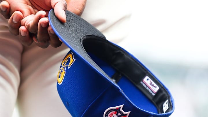 A member of the Seattle Mariners holds a baseball hat with a patch honoring the victims of the September 11th terrorist attacks before the game against the Atlanta Braves at T-Mobile Park.