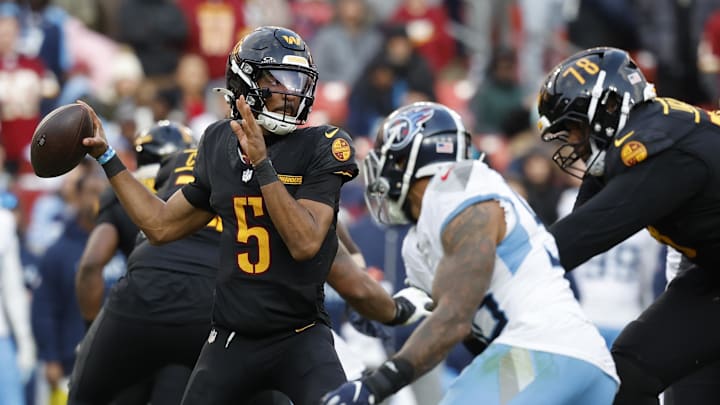 Dec 1, 2024; Landover, Maryland, USA; Washington Commanders quarterback Jayden Daniels (5) passes the ball as Tennessee Titans linebacker Arden Key (49) chases during the third quarter at Northwest Stadium. Mandatory Credit: Geoff Burke-Imagn Images