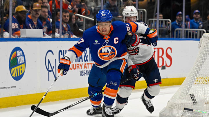 Nov 2, 2025; Elmont, New York, USA; New York Islanders left wing Anders Lee (27) plays the puck form behind the net defended by Columbus Blue Jackets defenseman Jake Christiansen (2) during the third period at UBS Arena. Mandatory Credit: Dennis Schneidler-Imagn Images Nov 2, 2025; Elmont, New York, USA; New York Islanders left wing Anders Lee (27) plays the puck form behind the net defended by Columbus Blue Jackets defenseman Jake Christiansen (2) during the third period at UBS Arena. Mandatory Credit: Dennis Schneidler-Imagn Images