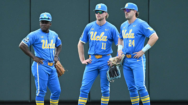 Jun 17, 2025; Omaha, Neb, USA;  UCLA Bruins left fielder Dean West (36) and center fielder Payton Brennan (11) and right fielder A.J. Salgado (24) wait out a pitching change against the LSU Tigers during the fourth inning at Charles Schwab Field. Mandatory Credit: Steven Branscombe-Imagn Images