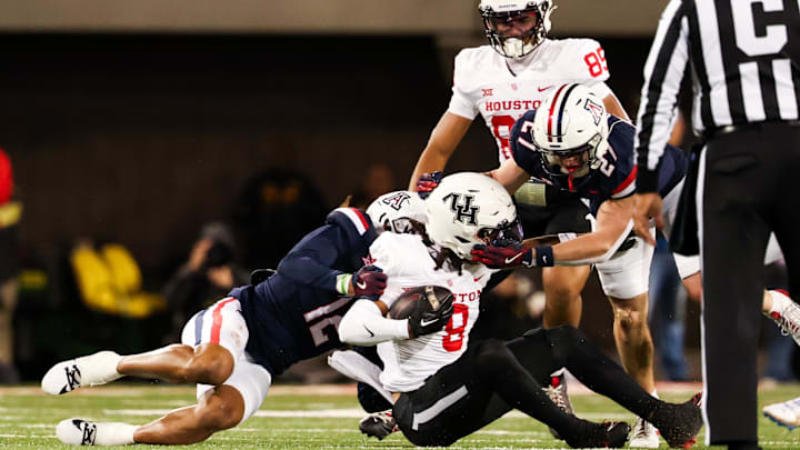 Nov 15, 2024; Tucson, Arizona, USA; Arizona Wildcats defensive back Genesis Smith (12) tackles Houston Cougars wide receiver Devan Williams (8) during the second quarter at Arizona Stadium. Mandatory Credit: Aryanna Frank-Imagn Images