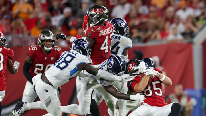 Aug 9, 2025; Tampa, Florida, USA; Tennessee Titans linebacker Curtis Jacobs (57) grabs the helmet of Tampa Bay Buccaneers wide receiver Garrett Greene (85) in the second quarter during a preseason game at Raymond James Stadium. Mandatory Credit: Nathan Ray Seebeck-Imagn Images
