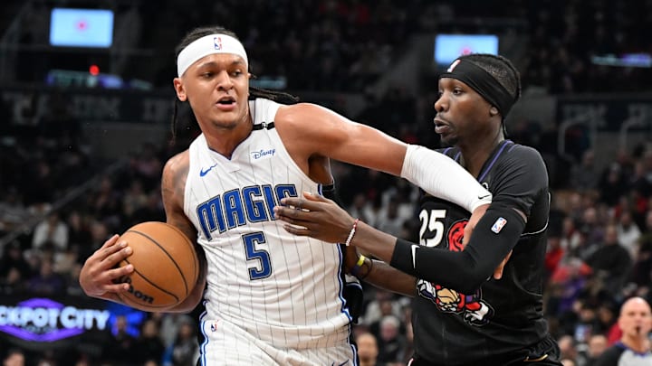 Jan 21, 2025; Toronto, Ontario, CAN;  Orlando Magic forward Paolo Banchero (5) pushes off Toronto Raptors forward Chris Boucher (25) in the first half at Scotiabank Arena. Mandatory Credit: Dan Hamilton-Imagn Images