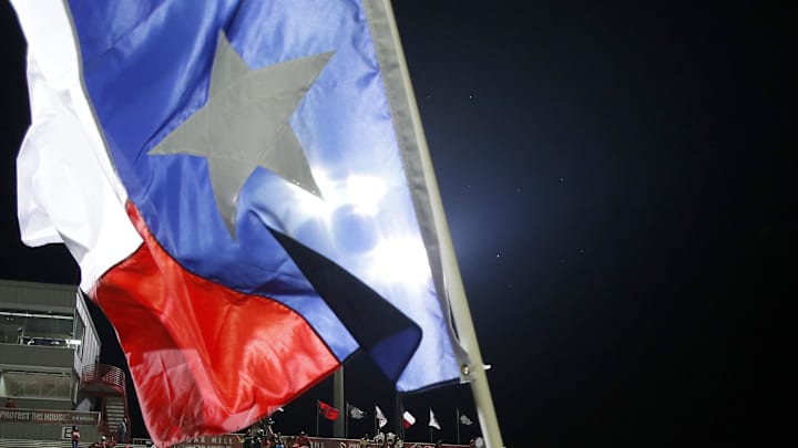 Aug 27, 2016; Cedar Hill, TX, USA; A member of the Cedar Hill cheer team waves a Texas flag after the game against the Bishop Gorman Gaels at Longhorn Stadium. Bishop Gorman won 44-14. Mandatory Credit: Tim Heitman-Imagn Images