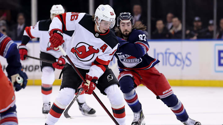 New Jersey Devils center Jack Hughes (86) plays the puck against New York Rangers center Mika Zibanejad (93). Mandatory Credit: Brad Penner-Imagn Images