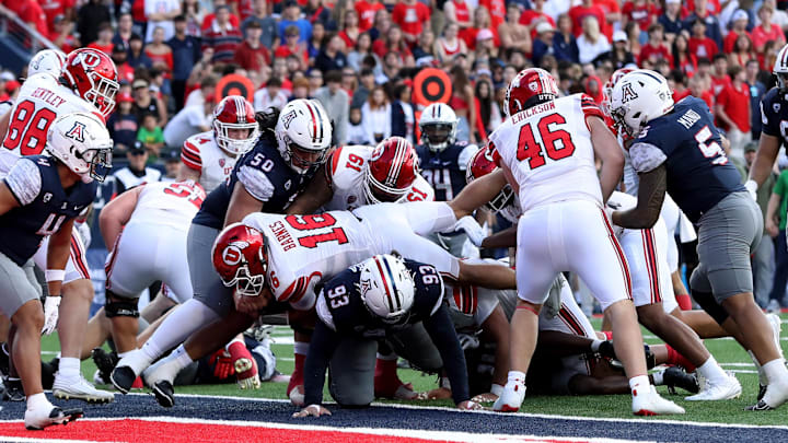 Nov 18, 2023; Tucson, Arizona, USA; Utah Utes quarterback Bryson Barnes (16) dives into the end zone for a touchdown against Arizona Wildcats defensive lineman Jacob Kongaika (93) during the second half at Arizona Stadium. Mandatory Credit: Zachary BonDurant-Imagn Images