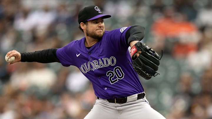 Peter Lambert throws a baseball in a purple rockies unifor