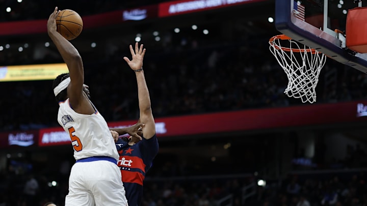 Dec 28, 2024; Washington, District of Columbia, USA; New York Knicks forward Precious Achiuwa (5) dunks the ball over Washington Wizards forward Kyshawn George (18) in the second quarter at Capital One Arena. Mandatory Credit: Geoff Burke-Imagn Images
